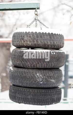 Boxing pear hanging made from the tires chained outdoors. Training and hardening fighting spirit in any weather. Street trainer for a workout, do it yourself. Closeup. Stock Photo