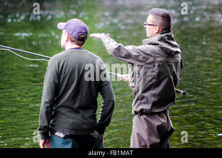 Fly fishing young men learn to fish on the Ness River in Inverness Scotland. Stock Photo