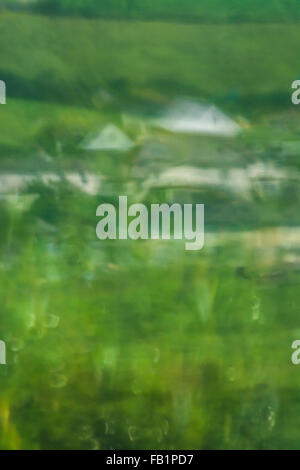 Distorted window-reflected abstract image of a cluster of houses set in a rural village. Stock Photo
