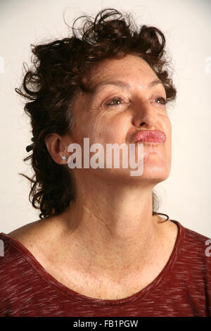 An adult woman imitates the expressions of a baby. Stock Photo