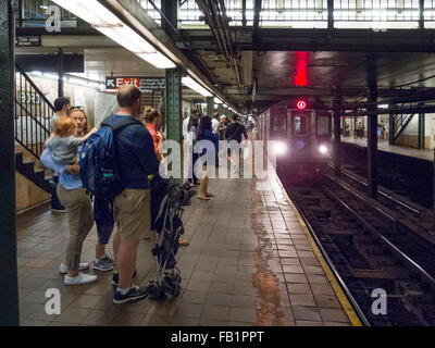 Passengers await the arrival of a subway train at Borough Hall station in Brooklyn, New York. Note child at left. Stock Photo