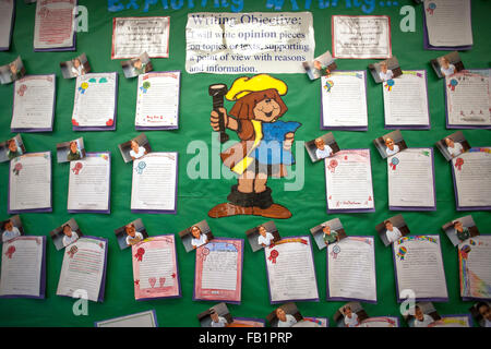 A bulletin board in a San Clemente, CA, third grade classroom exhibits examples of student written opinion pieces involving supporting text and a clear point of view. Note humorous illustration and portrait photos of students accompanying writings.