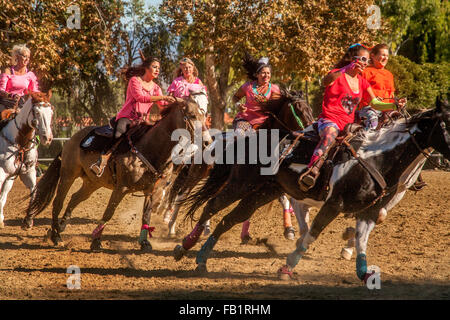 Multiracial adult women ride their horses at full gallop at an equestrian meet in Laguna Woods, CA. Stock Photo