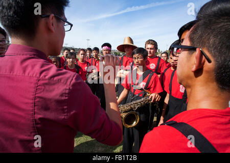 A Vietnamese-American high school marching band director leads his multiracial musicians in singing before a band competition in Mission Viejo, CA. Stock Photo