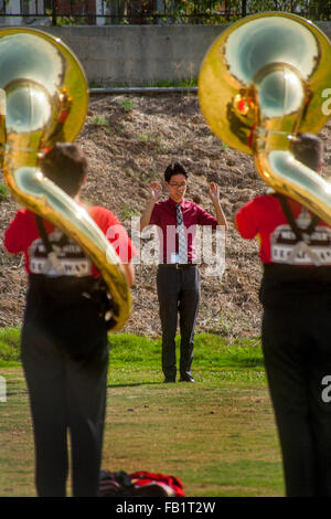 A Vietnamese-American high school marching band director leads his multiracial tuba players in practice before a band competition in Mission Viejo, CA. Stock Photo