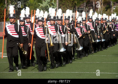 In full uniform and carrying their instruments, a multiracial high school marching band takes the field at a countywide band competition in Mission Viejo, CA. Stock Photo