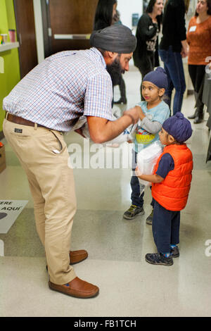 A Sikh father talks with his two sons in Costa Mesa, CA. Note turbans worn as a religious observance. Stock Photo