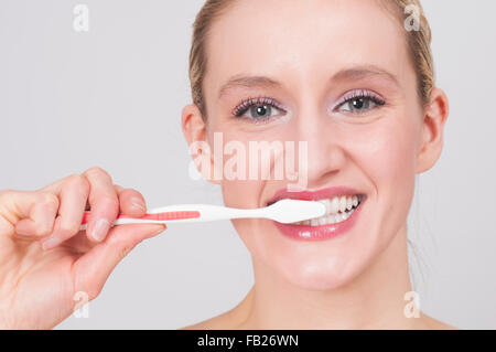 Young woman brushing her teeth with toothbrush Stock Photo