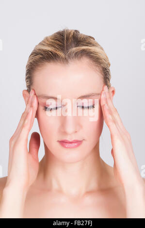 Young woman massaging her temples Stock Photo