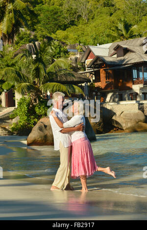 Elderly couple standing embracing outdoors Stock Photo