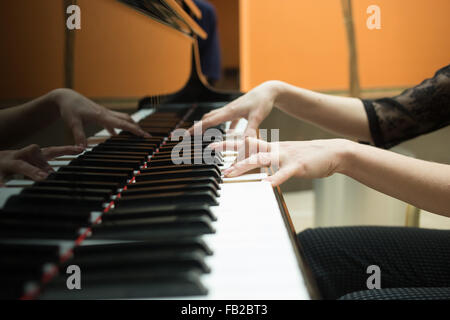 Women's hands on the keyboard of piano. girl plays music Stock Photo