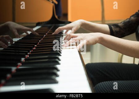 Women's hands on the keyboard of piano. girl plays music Stock Photo