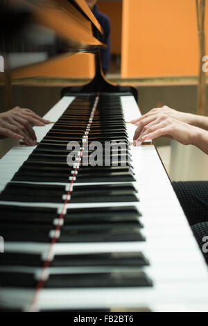 Women's hands on the keyboard of piano. girl plays music Stock Photo