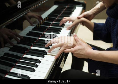 Women's hands on the keyboard of piano. girl plays. music teacher Stock Photo