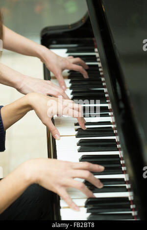 Women's hands on the keyboard of piano. girl plays music Stock Photo