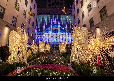 Christmas Angels at Rockefeller Center Channel Gardens with Saks department store’s Christmas light show behind, New York, USA Stock Photo