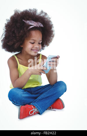 Cute girl sitting on floor using smartphone Stock Photo