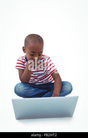 Happy boy sitting with laptop in front of wall Stock Photo - Alamy