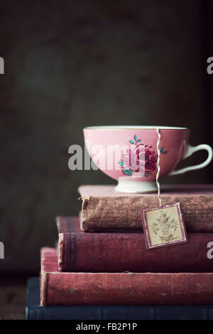 Vintage teacup on stack of old books Stock Photo