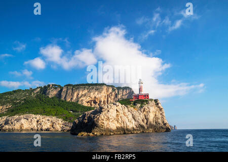 Punta Carena Lighthouse on the coastal rocks at the Mediterranean Sea in Capri island, seen from a motor boat tour.