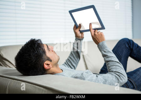 Handsome man using tablet on the sofa Stock Photo