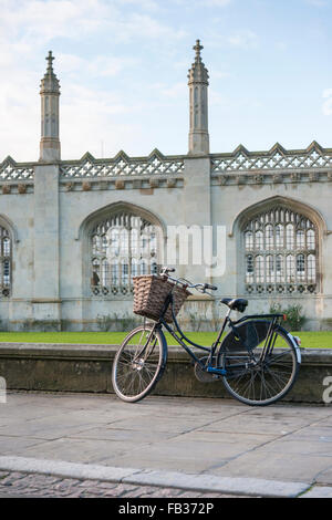 A traditiojnal pedal cycle or bicycle or bike parked against a wall outside Kings College Chapel Kings Parade Cambridge UK Stock Photo