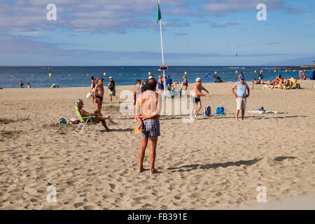 Groups of retirees playing petanque with steel bowls on the sandy beach of Las Vistas in Los Cristianos, Tenerife, Canary Island Stock Photo