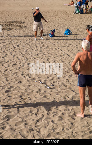 Groups of retirees playing petanque with steel bowls on the sandy beach of Las Vistas in Los Cristianos, Tenerife, Canary Island Stock Photo