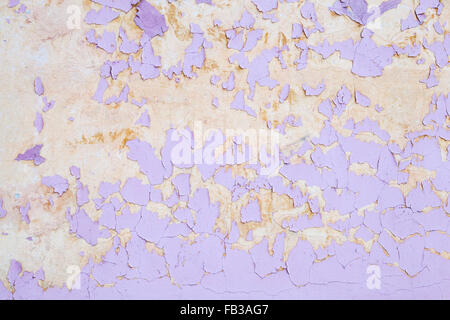 Cracked pink flaking paint layer over yellow wall, background texture Stock Photo