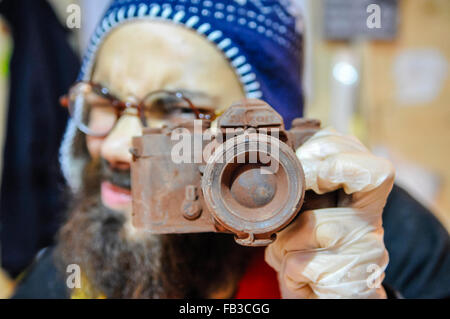 A market stall holder holds up an SLR camera made entirely from chocolate. Stock Photo