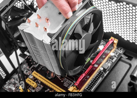 Hands installing a fan on the motherboard. Stock Photo