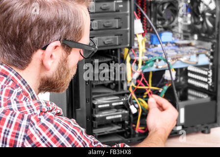 Computer engineer repairs the computer. Stock Photo