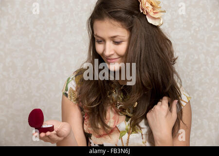 Smiling girl looks at the ring in heart shaped box Stock Photo