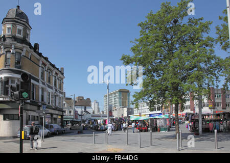 Street market in Beresford Square, Woolwich, south east of London UK. Shows clothes stalls and pedestrians. Stock Photo