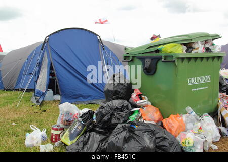 Rubbish overflows from a bin next to festival goers' tents - final day of  the Y Not festival, Pikehall, Derbyshire Stock Photo