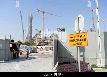 A sign reading 'Construction Zone - Keep Away' stands at an entrance to the construction site of the Khalifa International Stadium in Doha, 09 January 2016. The stadium is currently undergoing renovation works. The Khalifa International Stadium is the first proposed host venue for the 2022 FIFA World Cup Qatar. In background is the hotel 'The Torch'. Photo: Andreas Gebert/dpa Stock Photo