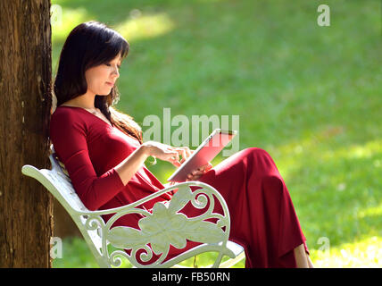 pretty woman using  tablet in the garden Stock Photo