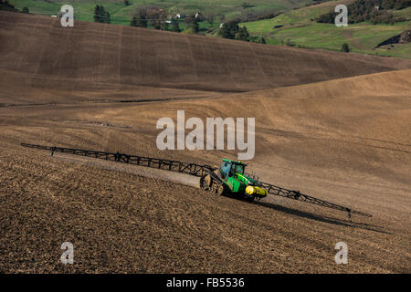 John Deere track tractor configured with spraying booms spraying ...