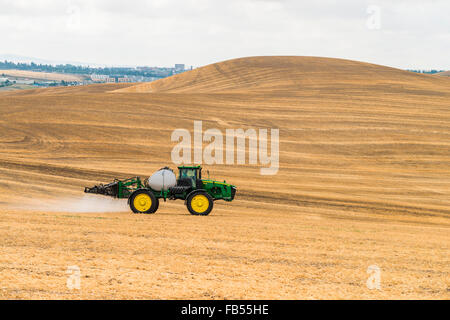 John Deere self propelled sprayer spraying herbicide on a field in advance of preparing it to plant in the Palouse region of Eas Stock Photo