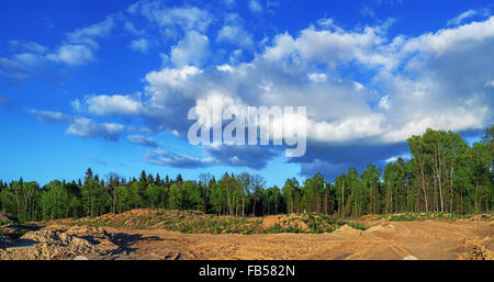 Construction of Vitebsk hydroelectric power station.Clay and earth hills stored on the river coast near building of a dam. Stock Photo