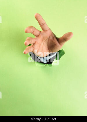 hand gesture break through green paper with action Stock Photo - Alamy