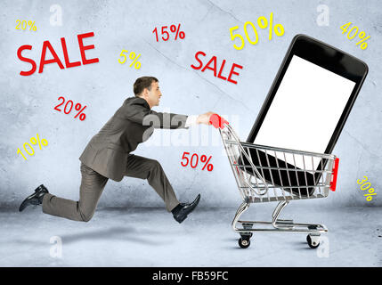 Businessman with smartphone in shopping cart Stock Photo