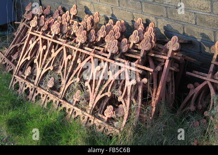 Stack of old Iron railings sat on the grass Stock Photo