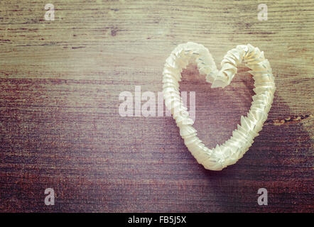 Vintage stylized heart made of shells on wooden background, space for text. Stock Photo