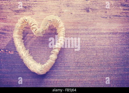 Vintage stylized heart made of shells on wooden background, space for text. Stock Photo