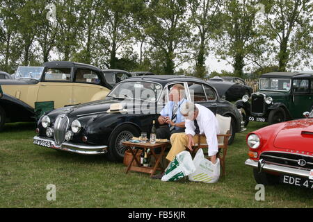 Visitors having a picnic amongst classic cars at Goodwood Revival Stock Photo