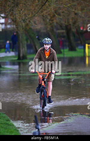 Tonbridge, Kent, England 10th January 2016: A youth plays on his BMX bike in floodwater on a playing field in Tonbridge. Recent heavy rain has left the playing fields partially flooded and the ground saturated, and the River Medway (which flows through the town) is currently bank full. Credit:  James Brunker/Alamy Live News Stock Photo