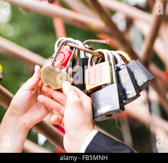 Many marriage love symbol padlocks chained on bridge Stock Photo