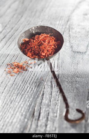 saffron in old spoon on wooden backgound Stock Photo