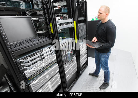 It engineer maintains servers in datacenter Stock Photo